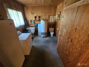 Utility room in the garage with toilet and utility sink.