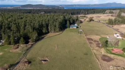 Sunny, idyllic, island farmstead with a main residence, guesthouse, barn, outbuildings, fenced garden, greenhouse, chicken coop with covered run, and more on ten pristine acres of field and forest overlooking a lovely valley on Lopez Island