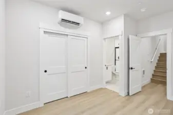 Stairs to lower level highlight entry into 5th bedroom perfect for a private guest suite or potential office