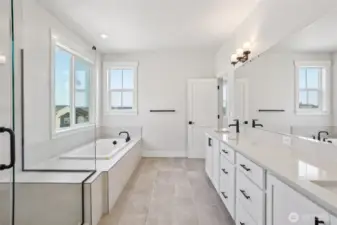 A gorgeous 5-piece primary bath ensuite features a soaking tub and shower with a bench seat.