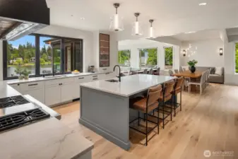 Designer kitchen featuring a large quartz island, high-end appliances, and panoramic lake views.