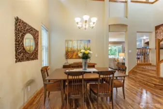 Host dinner parties in this sun-drenched dining area. The open-concept layout and high ceilings provide an airy atmosphere, while the proximity to the grand staircase adds a touch of architectural drama.