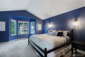 King-sized primary suite featuring large picture windows and a tranquil atmosphere.