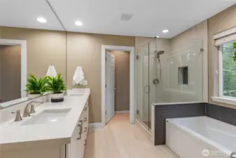 Luxurious five-piece bath with a dedicated makeup vanity, deep soaking tub, and custom-tiled walk-in shower.