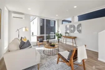 A cozy yet contemporary living room offers the perfect retreat after a busy day, featuring expansive windows and sleek finishes.