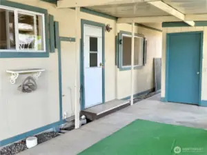 Close up of the carport with access to the utility room, backyard and storage unit.