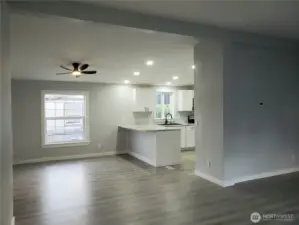 A View of the Dining Room and Kitchen from the Huge Living Room with Cathedral Ceilings, New Paint Trim and Vinyl Plank Flooring.