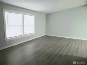 A Different View of the Huge Living Room with New Paint, Trim, Cathedral Ceiling and Vinyl Plank Flooring.