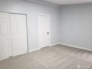 A Different View of the Primary Master Bedroom Showing Cathedral Ceilings, All New Paint, Trim and Carpeting Looking at the Walk In Closet and Primary Master Bath Room.