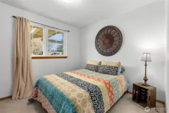 Second bedroom with carpet flooring, window, and closet space.