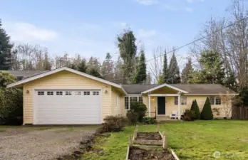 Single-level 3-bedroom home with detached two-car garage on a .28-acre lot in Hansville, Washington, offering a quiet setting and mature landscaping.