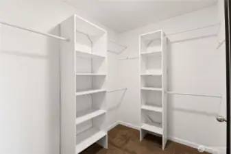 Primary bedroom walk in closet with closet organizer system
