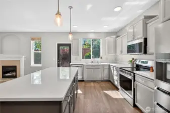 Bright kitchen with large island and sink window overlooking private backyard