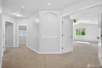 Upstairs hallway showcasing layout of secondary bedrooms, bathroom, and primary suite
