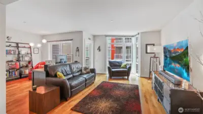 Living room with floor to ceiling windows, refinished walnut floors.