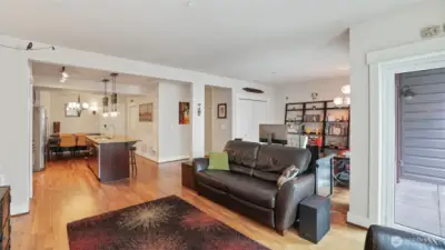Living room with floor to ceiling windows, refinished walnut floors.