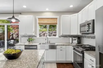 Granite slab counters adorn the kitchen and pair perfectly with the stainless steel appliances.