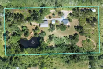 Aerial drone photo shows property lines and layout of buildings and pond with soothing aeration fountain.