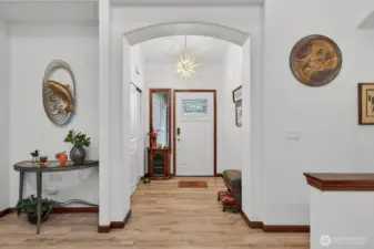 A warmly inviting and well-lit entryway is a key feature, complemented by the practical addition of convenient closet storage solutions for maintaining an organized and functional home entrance.