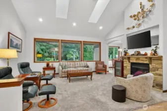 The living room features large, inviting windows that flood the space with natural light, creating a warm and cheerful atmosphere, while also providing delightful views of your own, tranquil, and private backyard patio, perfect for relaxation and enjoyment.