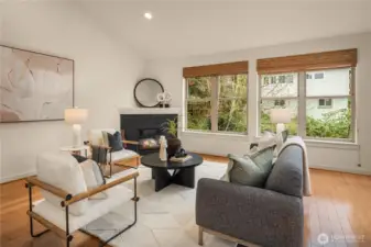 A gas fireplace adds an inviting atmosphere to this oversized living room with wood floors.