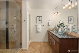 The en-suite features extensive tiling, heated floors, a separate water closet and double vanity with vessel sinks.