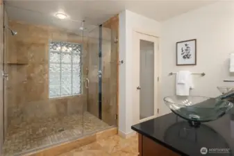 The luxurious shower features extensive tiling, dual shower heads and a frameless glass surround.