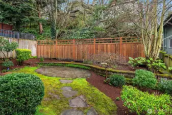 A flagstone path and patio with raised beds is a picture to behold in this fully fenced backyard.