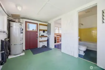 The back utility room is very spacious and has hook-ups for the washer and dryer, as well as a newer hot water heater and access to the easterly side yard, the kitchen and the bathroom.