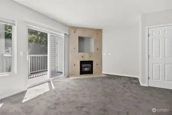 Living room with gas fireplace and slider out to balcony