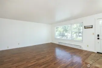 Walking into main living dining area with large windows.