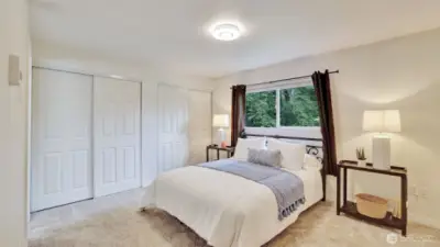 Spacious primary bedroom offers two closets and ample space for furniture or sitting area.
