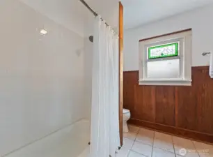 Refreshed main floor bathroom features new tub and tile surround