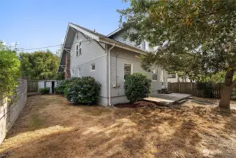 Fully fenced, the side yard has mature landscaping and room for pups to run!
