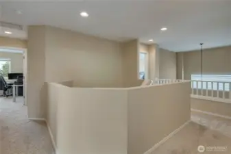 Upstairs hallway with railing open to below dining room.