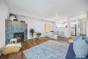 Open-concept living with new LVP flooring (2024) and a stunning coastal-blue gas fireplace as the centerpiece.