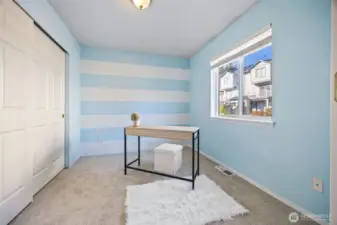 Bright, light-filled third bedroom currently staged as a home office; flexible and functional.