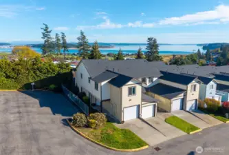From above, see how this end-unit townhome blends privacy and proximity — surrounded by open skies and coastal scenery. A peaceful retreat just minutes from NAS Whidbey Island, Windjammer Park, and downtown Oak Harbor.