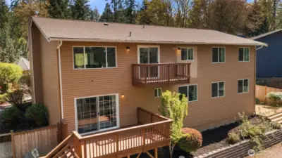 Backyard deck is perfect for entertaining, enveloped by a beautiful green space!