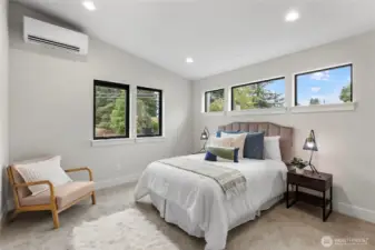 This bedroom offers a calm, inviting atmosphere with soft tones, layered textures, and abundant natural light. Thoughtful furnishings and a clean layout make it an ideal space for rest and relaxation.