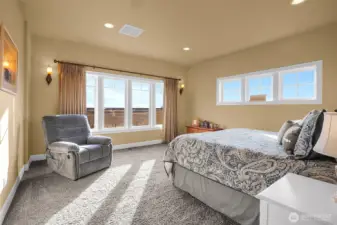 Your main-level primary suite, overflowing with natural light, facing the valley, vineyard, and lake, is a private retreat at the end of a beautiful day. Bathroom suite is to the left.