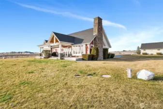 Two-story design with a magnificent chimney built from the large stones from the property enhances space, light, and architectural presence. Out here nearby is where you'll find the wellhead and covers for your private septic tank.
