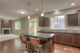 This shot from the kitchen is basically a blueprint for entertaining success. From the island, you have the perfect vantage point, overlooking the sink window and into the casual dining area in front of the slider, which opens up to the family room beyond. Whether you're prepping a meal, pouring drinks, or catching up with guests, this open layout ensures you never miss a moment.