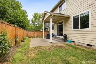 Enjoy the low-maintenance lifestyle with this backyard that lets you spend more time having fun and less time working. The covered patio near the slider keeps your BBQ plans rain-free, and the uncovered area gives you space for seating or outdoor activities. Rose bushes and easy-to-care-for plantings along the fence add beauty without the effort. The lawn extends right up to the house, offering a manageable area with room for a trampoline or whatever else you want to make the space your own.