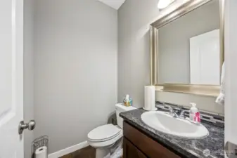 Your guests won’t be rushing out of this powder room anytime soon. With a tall ceiling that gives it a grand feel, a stunning granite countertop with a glass backsplash, and a coffee-tone shaker vanity that’s all about elegance, this space has everything you need. The large framed mirror ensures you’ll leave looking your best. Who knew powder rooms could be this chic?