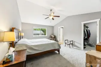 This primary suite is all about living large, without the heavy lifting. Vaulted ceilings and a ceiling fan keep the air moving and the space feeling open. The large window overlooks the backyard, giving you a front-row seat to nature's show without leaving the bed. The neutral carpeting is as soft as your excuses for staying in bed all day, and the walk-in closet? Let’s just say it’s large enough to house your entire wardrobe, and then some. There’s even room for a sitting area or a desk setup.