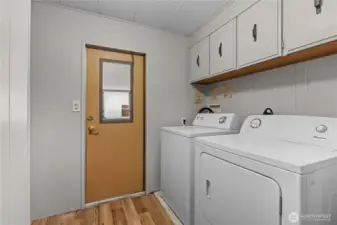 Laundry room has some linen storage and exits onto the carport.