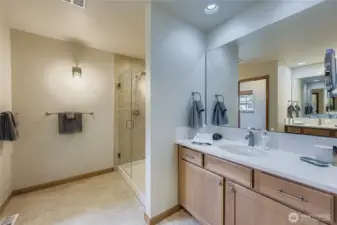 Primary Bath with dual sinks, water closet, and large shower with custom glass door.