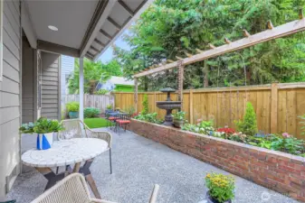 Let's call this a backyard oasis! Poured patio and brick planter hardscaping, partially covered, fully fenced, and the most beautiful turf-lawn all year round!