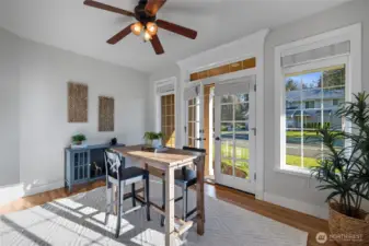 A second home office with exceptional natural light, hardwood floors, and French doors that lead to a covered porch.